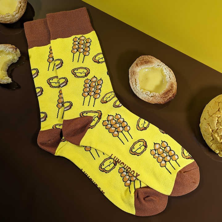 'Flavours of Hong Kong' socks featuring curry fish balls and egg tart designs sitting next to egg tarts